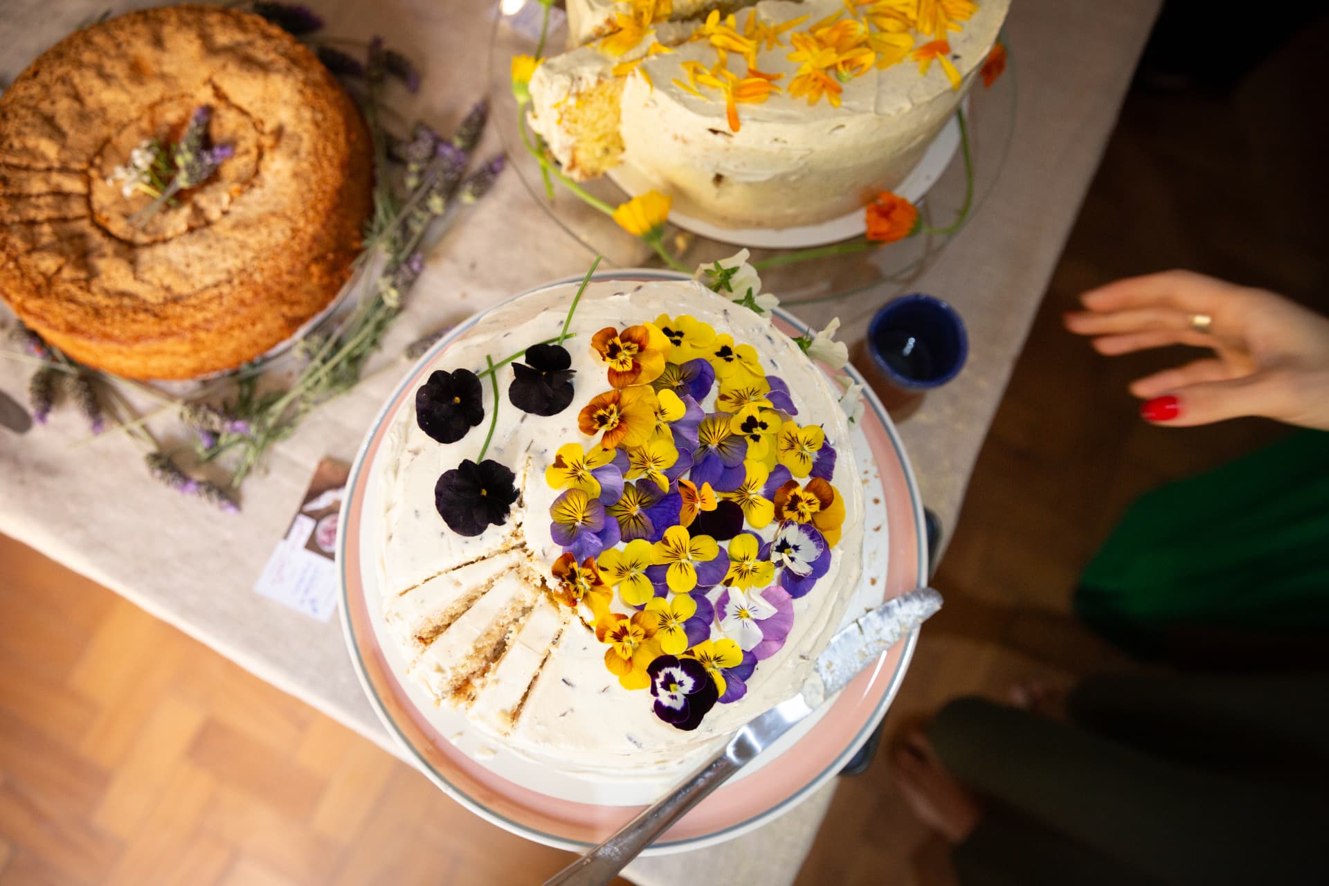 Bolo coberto com flores comestíveis amarelas e violetas